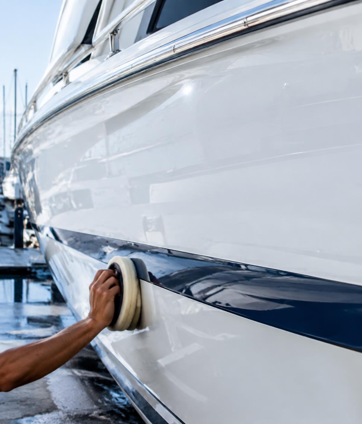 Yacht hull being polished and waxed to a mirror finish